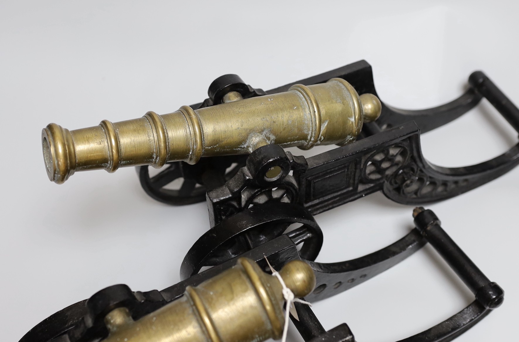 A pair of cast iron and bronze model cannons and a cast iron ‘dog’ nut cracker, cannons 42.5cm long